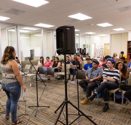 Woman talking in front of crowd