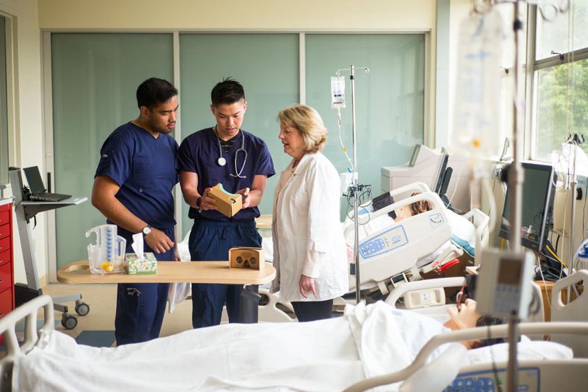 Two nursing students discuss the VR headset with their director.